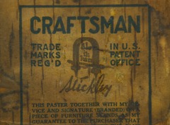 Close up Gustav Stickley signature paper label and guarantee on back of cabinet.